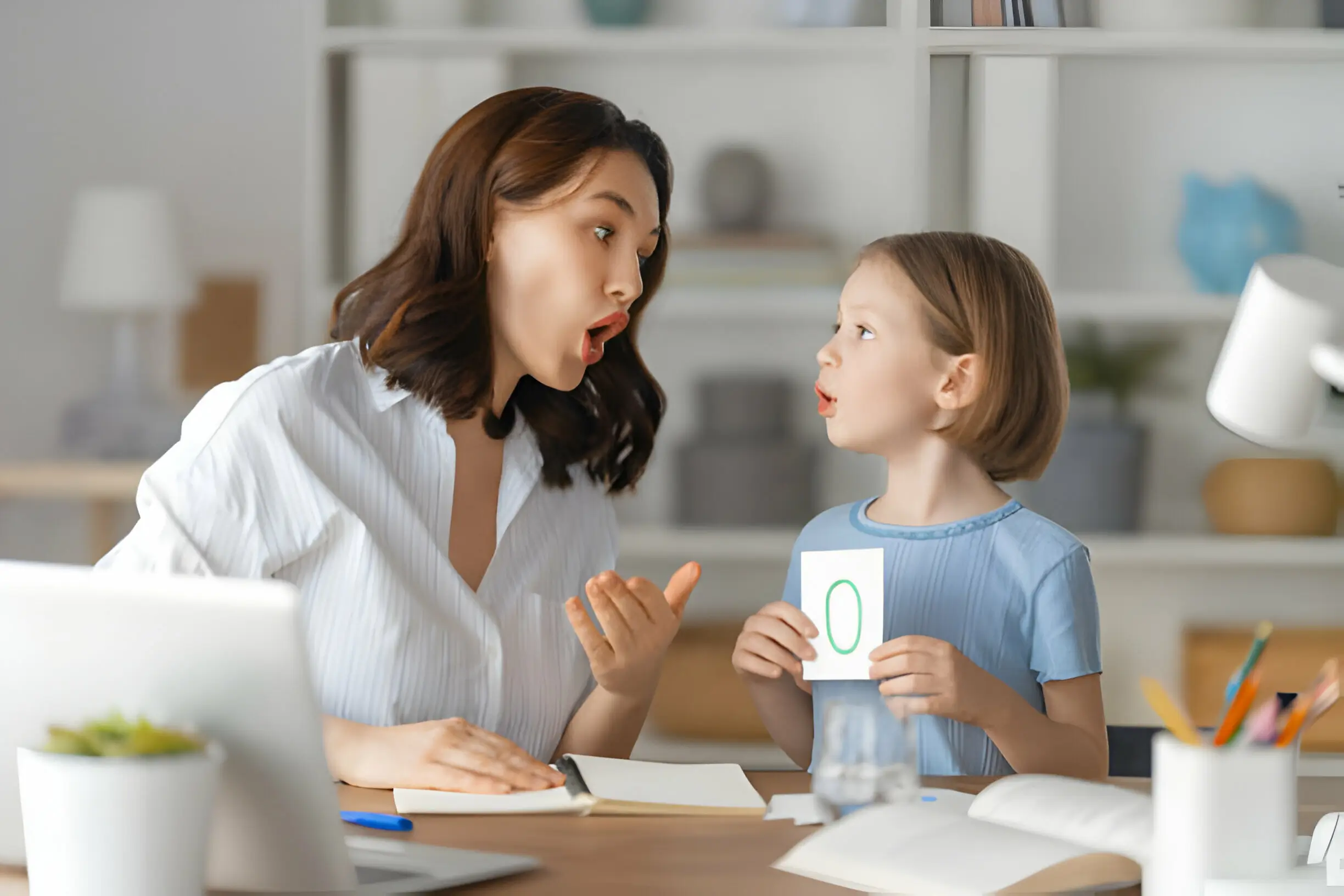 A mother and daughter having a playful moment during a home learning session – excitement and surprise on their faces.