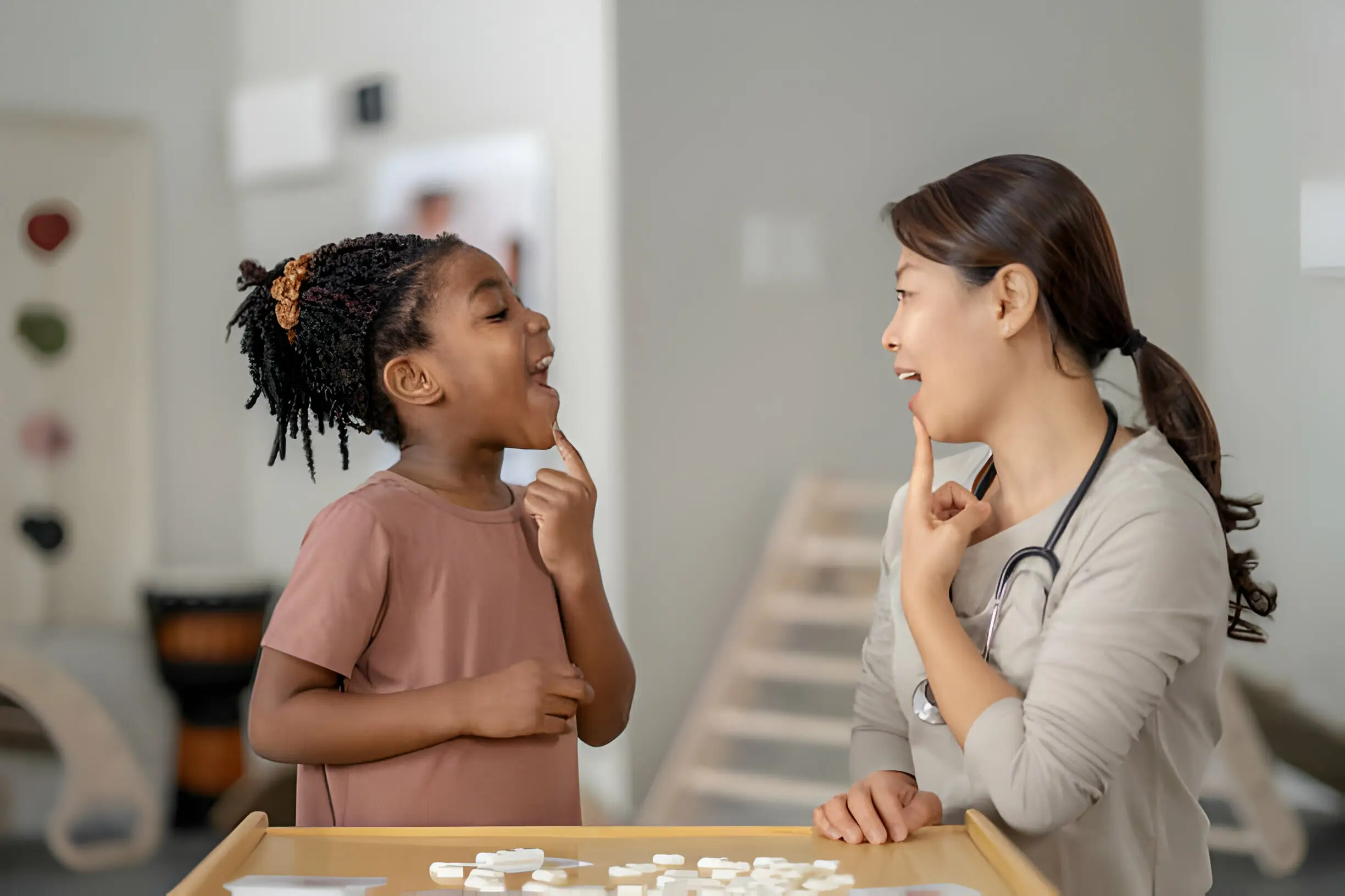 Speech therapist helping a kid with speech therapy exercises